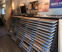 Mehrere Schichten Laminatboden-Muster in einem Geschäft mit dem Schild „Quick-Step“.