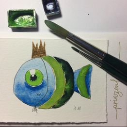Gemaltes Fischbild mit Krone neben zwei grünen Pinseln und Aquarellfarben auf Papier.