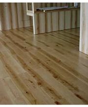 Hellbrauner Holzfußboden mit deutlicher Maserung in einem Raum mit Holzwänden.