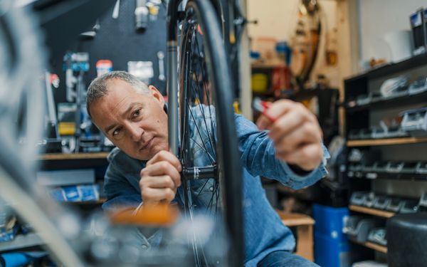 Fahrradmechaniker prüft die Unwucht eines Fahrradreifens.
