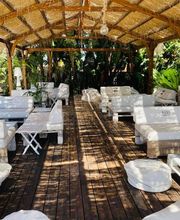 Sala de estar al aire libre con sofás blancos bajo techo de madera.