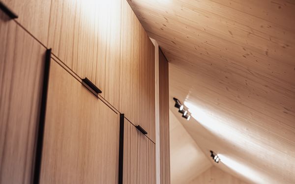 Ein Holzschrank eingebaut unter eine Dachschräge.