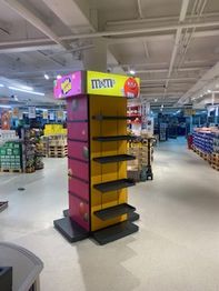Leeres M&M's-Verkaufsregal in einem Supermarkt mit gelbem und rotem Design.