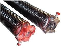 Close-up of two coiled garage door springs with red end caps.