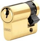 Cilindro de cerradura dorado con logotipo, visto de perfil lateral.