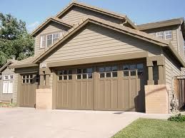 Tan house with three garage doors and a driveway in front.