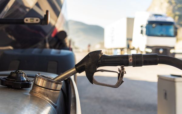 Ein LKW an einer Tankstelle, der gerade betankt wird.