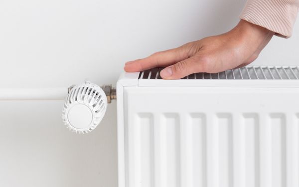 Hand liegt auf kalter Heizung