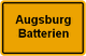 Ortsschild mit der Aufschrift „Augsburg Batterien“ auf gelbem Hintergrund.