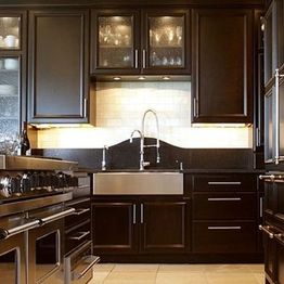 Modern kitchen with dark cabinets, a large sink, and stainless steel appliances.