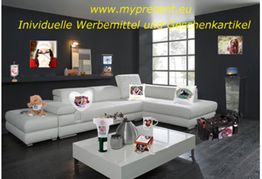 Wohnzimmer mit Werbemitteln und Geschenkartikeln auf weißen Möbeln. Webseite oben im Bild.