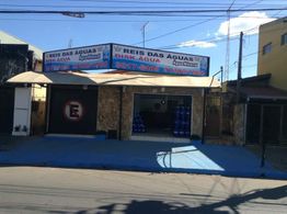 Fachada da loja "Reis das Águas" com galões de água expostos na entrada.