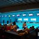 Bowlingbaan met mensen die bowlen; schermen boven de banen tonen scores.