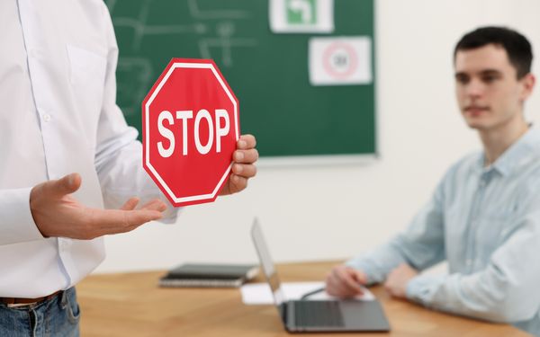 Fahrlehrer zeigt Schüler ein Stoppschild