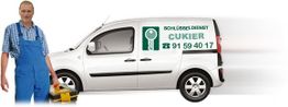 Mann in blauer Latzhose mit Werkzeug vor einem Lieferwagen mit Aufschrift "Schlüsseldienst Cukier".