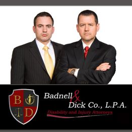 Two men in suits pose with arms crossed next to a law firm logo for disability and injury attorneys.