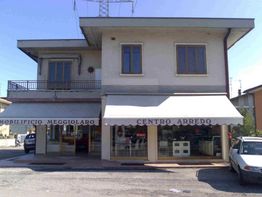 Edificio a due piani con negozio "Centro Arredo" al piano terra e auto parcheggiata davanti.
