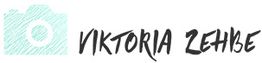 Skizzierte Kamera neben dem Namen "Viktoria Zehbe" in schwarzer Schrift auf weißem Hintergrund.