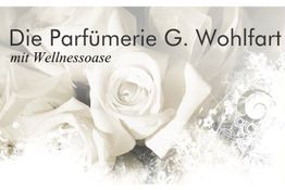 Weiße Rosen mit dem Text: "Die Parfümerie G. Wohlfart mit Wellnessoase" im Hintergrund.