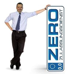 Geschäftsmann lehnt an einem großen Schild mit der Aufschrift "Zero Zulassungsdienst".