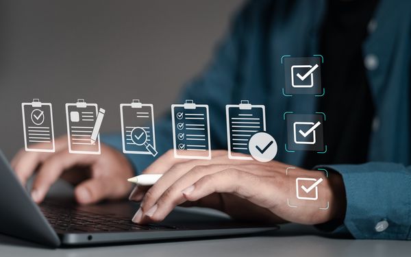 Ein Ghostwriter sitzt am Laptop und überprüft den Unternehmensbericht eines Kundens. Die Aufgaben, die er übernimmt werden als Grafik dargestellt. 