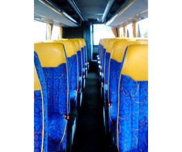 Innenraum eines leeren Busses mit blauen Sitzen und gelben Kopfstützen, Blick nach vorn.
