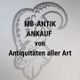 Text auf Glas: "MB-ANTIK ANKAUF von Antiquitäten aller Art" vor einem Logo mit Schafskopf.