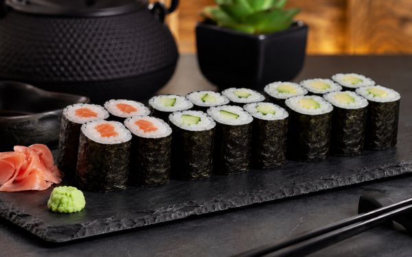 Verschieden gefüllte Hoso Maki auf einer Schieferplatte.