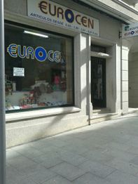 Fachada de tienda "EUROCEN" con escaparate y puerta de entrada, artículos variados adentro.