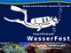 Taucher-Silhouette mit Blasen, Text "tauchteam WasserFest" und Unterwasserlandschaft mit Korallen.
