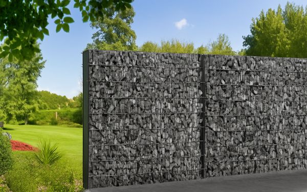 Zwei Gabionen-Zäune mit grüner Wiese im Hintergrund