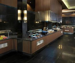 Cocina elegante con encimeras de madera y fruta a la vista en un ambiente moderno y oscuro.