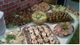 Tisch mit vielseitigem Buffet: belegte Brötchen, Fleisch, Obst und Gemüse auf Silbertabletts.