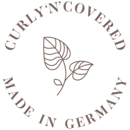 Logo mit zwei gezeichneten Blättern und Text: "Curly'N'Covered, Made in Germany".