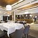 Elegant restaurant interior with white tablecloths and modern lighting.