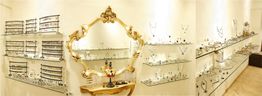 Schmuckladen mit goldverziertem Spiegel und Regalen voller Ohrringe, Ringe und Halsketten.