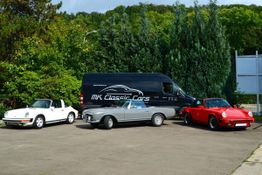 Drei klassische Autos und ein Transporter von "MK Classic Cars" stehen auf einem Parkplatz.