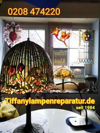 Tiffanylampen im Schaufenster, mit bunter Glasverzierung. Webseite: tiffanylampenreparatur.de.
