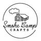 Logo of Smoke Camp Crafts with a log cabin and smoke rising within a circular border.