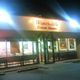 Winchell's Donut House exterior at night, with bright lights and glass window display.
