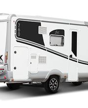 Autocaravana blanca y moderna estacionada, vista lateral y trasera.