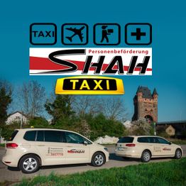 Zwei Taxis mit Shah-Logo vor einem historischen Turm bei blauem Himmel.