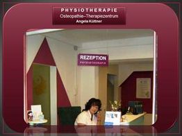 Rezeptionistin in einem Physiotherapiezentrum sitzt am Empfangstisch, Schild mit "Rezeption" oben.