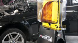 Auto-onderhoud met een Kroon-Oil PowerFlush-machine naast een open motorkap.