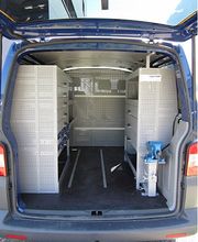 Offener Laderaum eines Transporters mit Regalsystemen und Werkzeugen auf beiden Seiten.