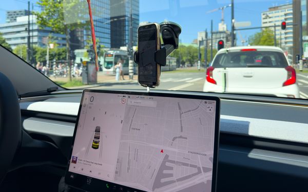 Der Display eines Software-Defined-Vehicle zeigt eine Navigation an. Das Auto ist mitten im Stadtverkehr unterwegs.