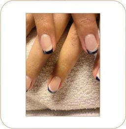 Nahaufnahme von Händen mit elegantem Nageldesign in Blau auf Handtuch.