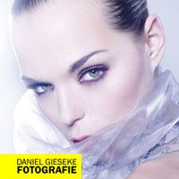 Nahaufnahme einer Frau mit leuchtenden Augen und einem transparenten Schal. Text: Daniel Gieseke Fotografie.