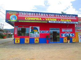 Fachada de imobiliária em Itanhaém, com placas de compra, venda e aluguel de imóveis.