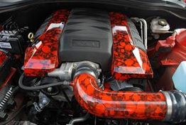 Roter Auto-Motor mit Totenkopf-Design auf Abdeckung und Ansaugrohr.